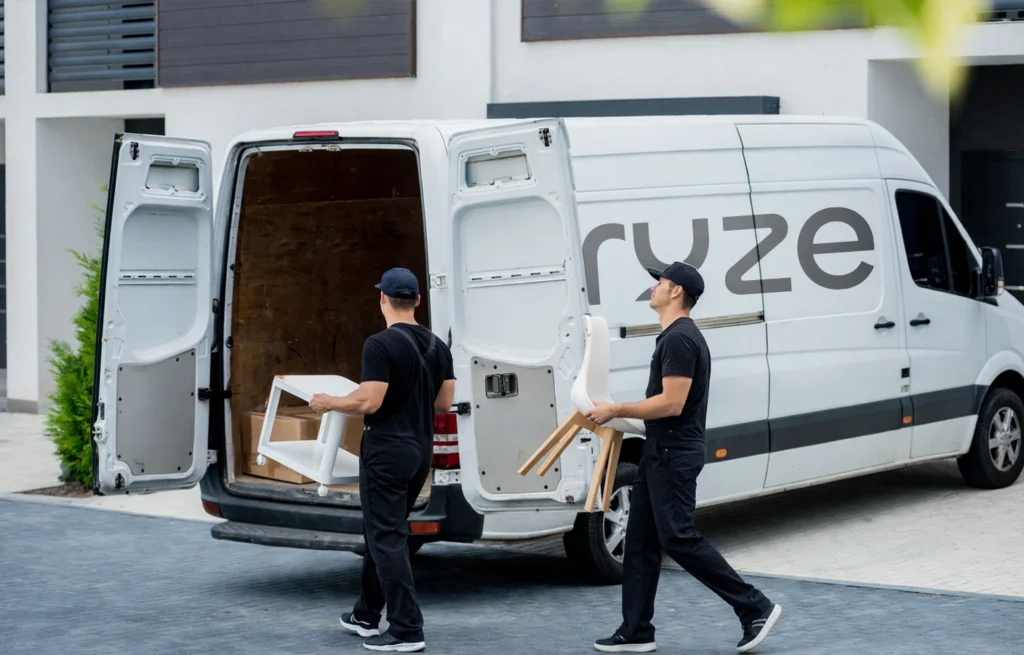 Kruze movers loading furniture items into a branded service van